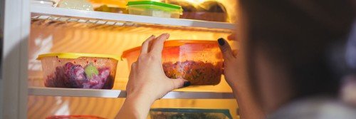 Person taking leftovers out of the refrigerator