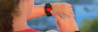 A woman who is exercising checks her heart rate.